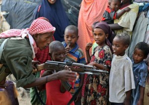 A government soldier on patrol in the streets of Somalia's war-torn capital demonstrates to Somali children how to use a Kalashnikov rifle during a gesture by the soldiers to win the goodwill of the residents of Mogadishu, on September 13, 2009. British intelligence chiefs have warned Prime Minster Gordon Brown's government that the number of young Britons travelling to Somalia to partcipate in terror-training camps is rising noting that the number of people with no direct family connection in Somalia travelling there per year had quadrupled to 100 since 2004. The Shebab, an Al-Qaeda inspired movement, is spearheading a three-month-old offensive to topple Somalia's President Sharif Sheikh Ahmed and has imposed strict Sharia law in areas under its control. AFP PHOTO/ MOHAMED DAHIR